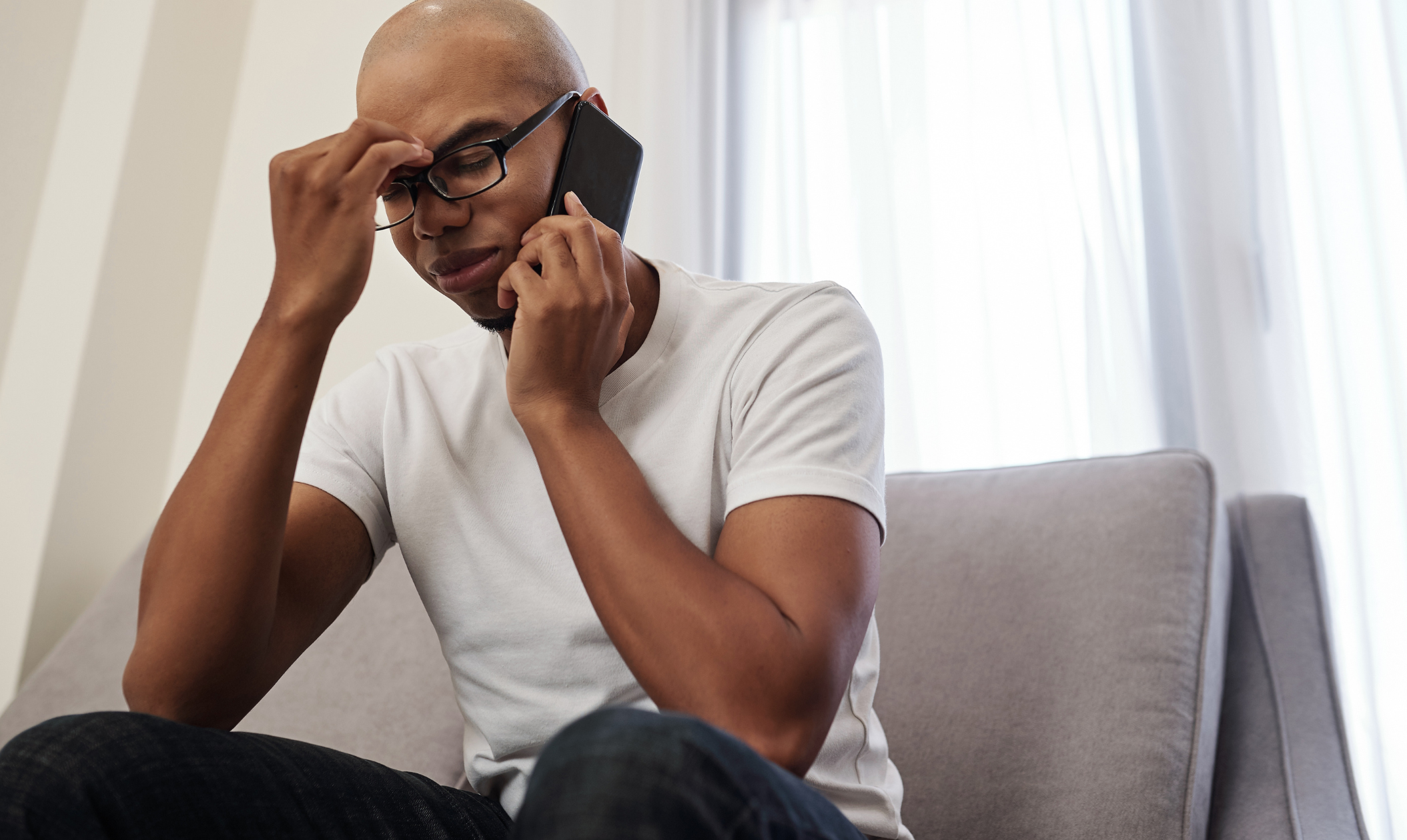 Man looking frustrated on a phone call, illustrating the stress when collection agencies call your family about your debt