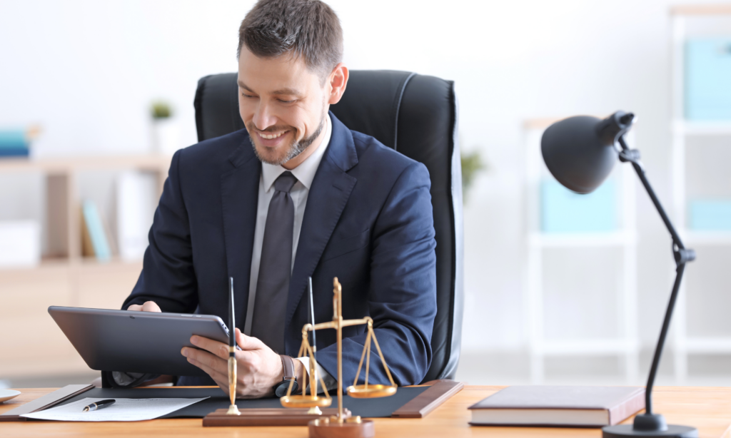 lawyers - Consumer Law Professionals Credit report lawyer at desk smiling due to fixing a clients credit report errors.